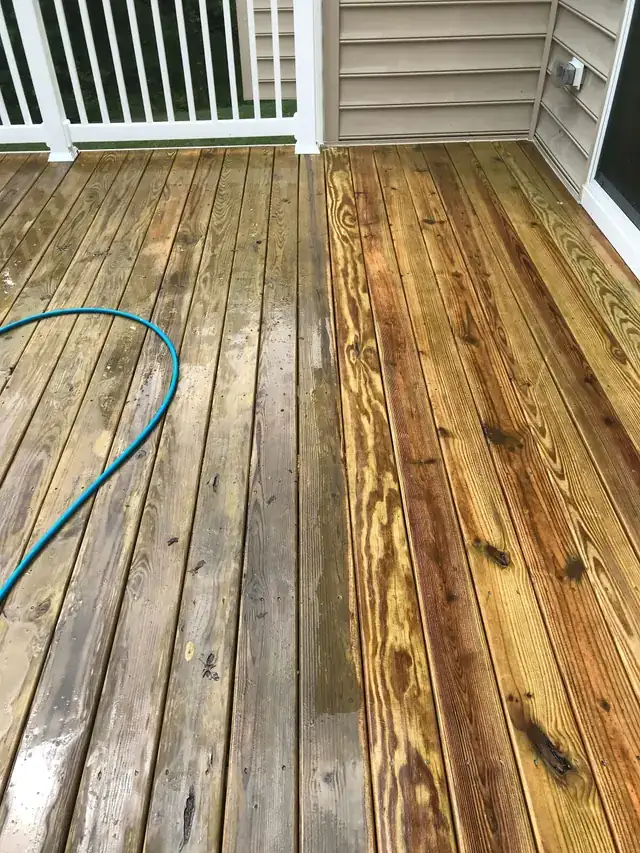 Deck boards half washed, grey weathered pine on the left and warm clean grain on the right